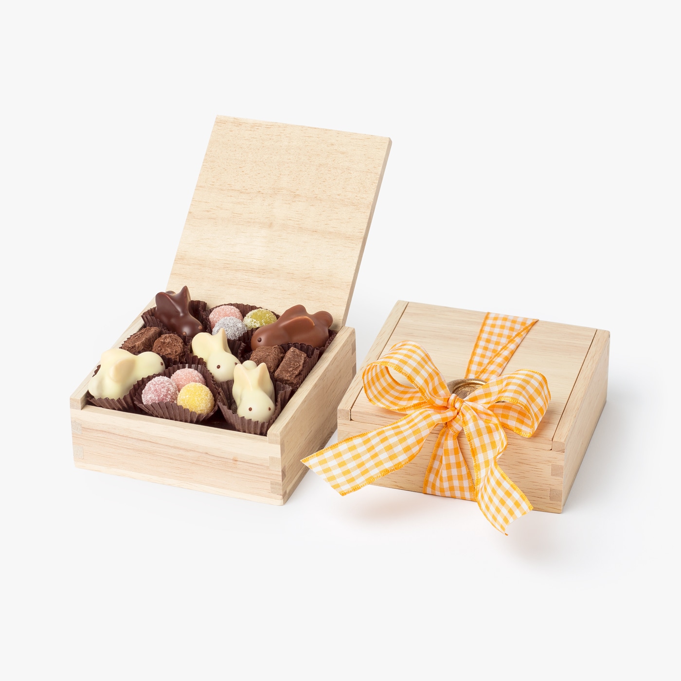 Handcrafted chocolate bunnies, marzipan eggs, and chocolate truffles inside a wooden box and ready to gift for Easter.